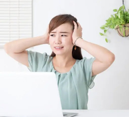 集中できずに頭を抱える女性
