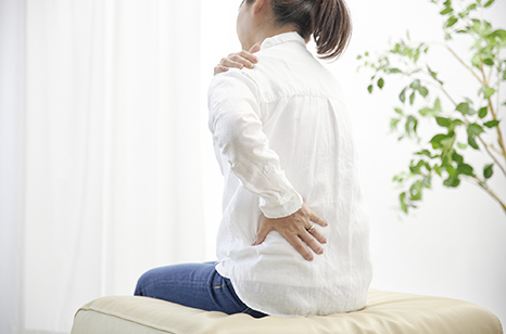 肩や腰のつらさを抱えて悩む様子